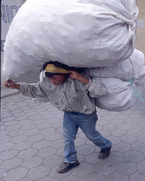 [Photo a person carrying a heavy load]