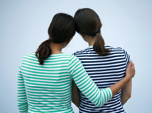 [Photo of tow young ladies with their arms around each other]