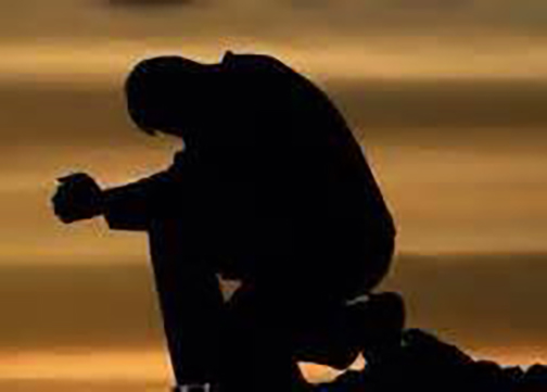 [Photo of the silhouette of a man praying]