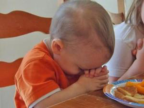 Photo of a small child praying