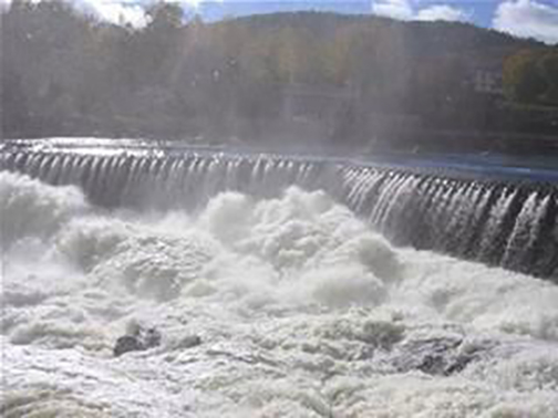 [Photo of water flowing over a dam]