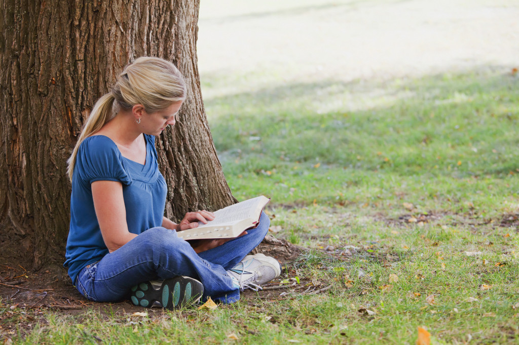 [Photo woman reading the Bible outdoors]