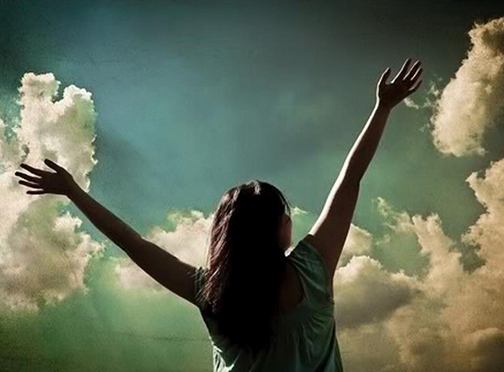 Photo of a woman with hands lifted in praise