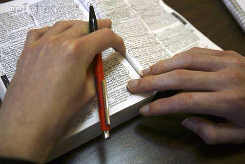 [Photo of a person writing in the Bible]